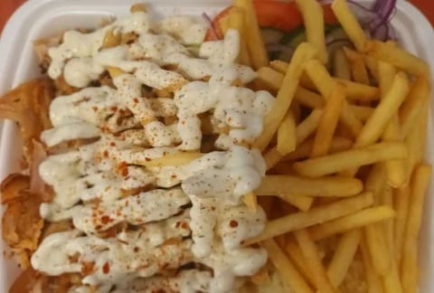 Plate of fried fish with creamy sauce, golden french fries, and coleslaw
