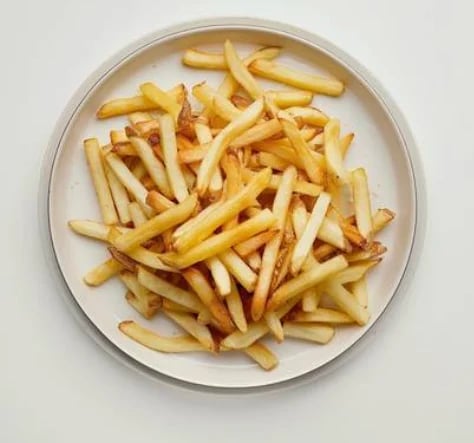Crispy golden French fries served on a white plate